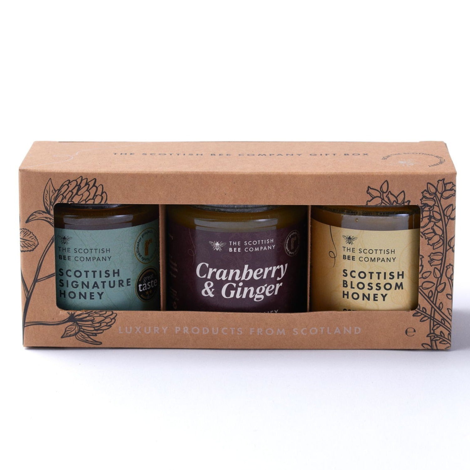 Three honey jars in a cardboard packaging with &