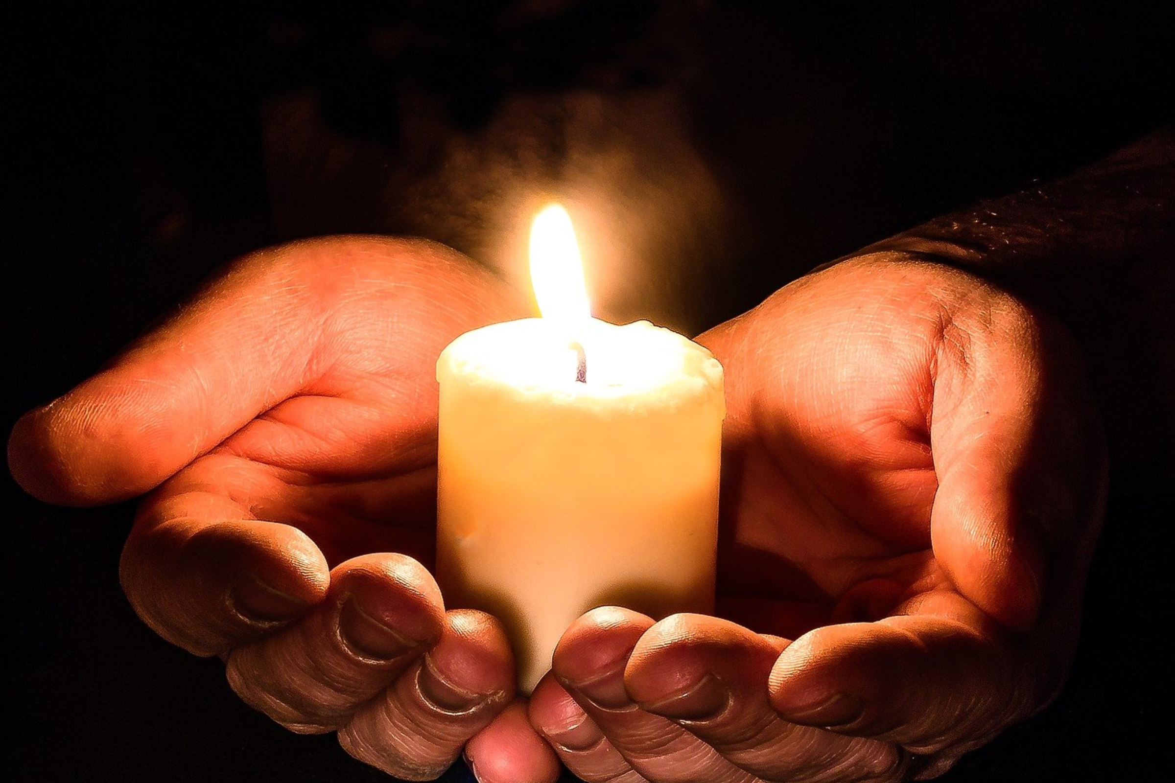 burning candle in hands without jars