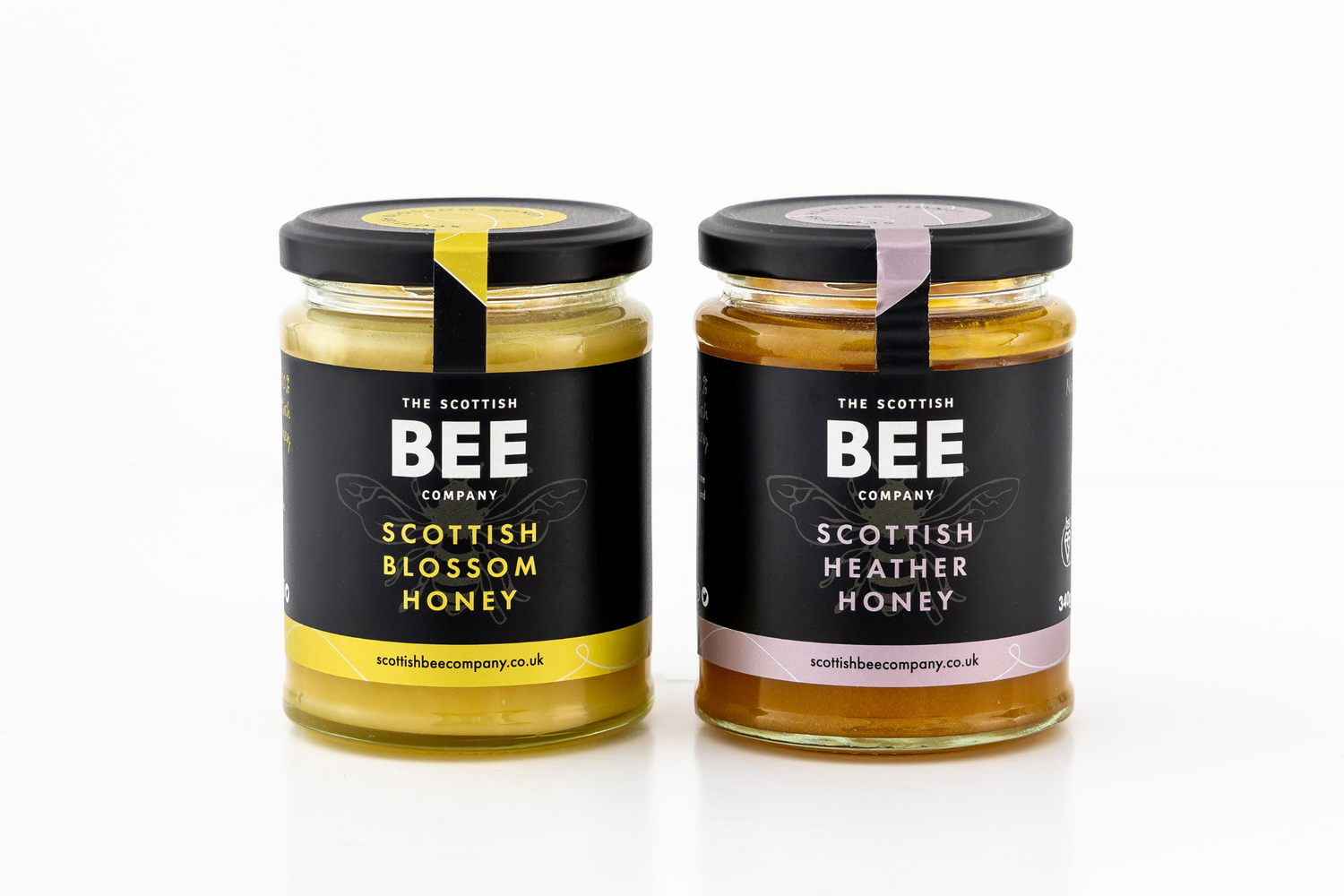 A jar of Scottish heather honey standing beside a jar off Scottish blossom honey