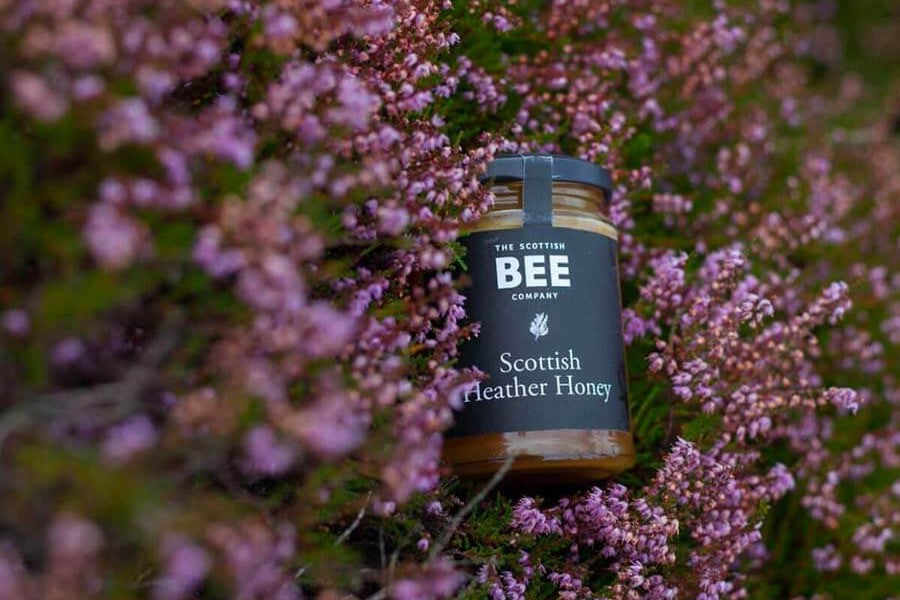 A jar of Scottish Heather Honey in a heather moor 