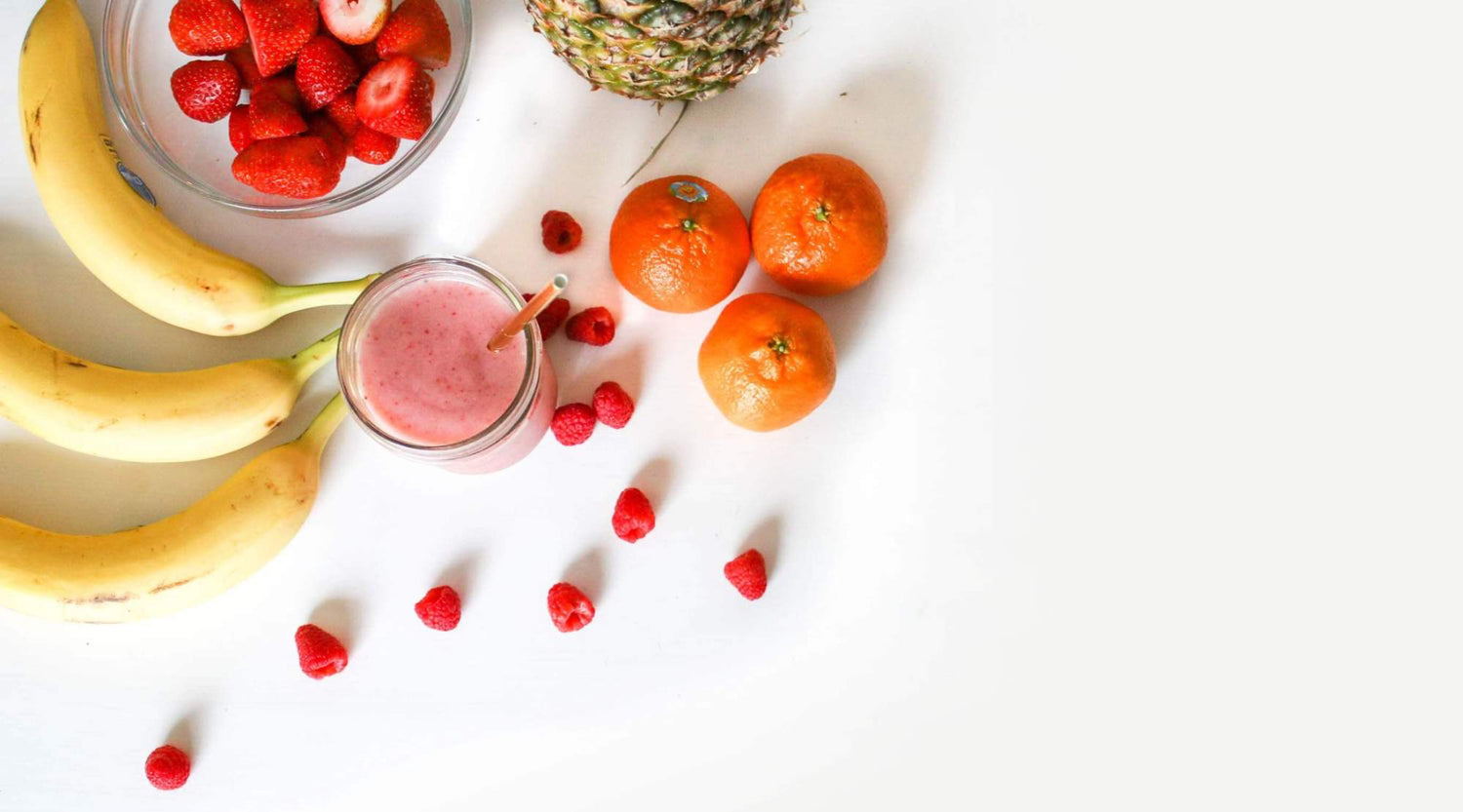 fruit smoothie in a glass with ingredients scattered around it