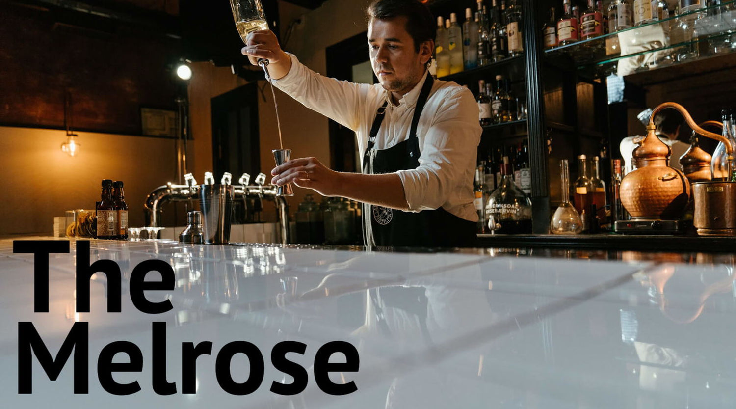 man pouring cocktail in classy bar with text 'the melrose'