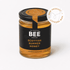 A glass jar of Scottish Summer Honey from The Scottish Bee Company, featuring a black label with gold and white text, a black lid with a gold seal, and a white circular &