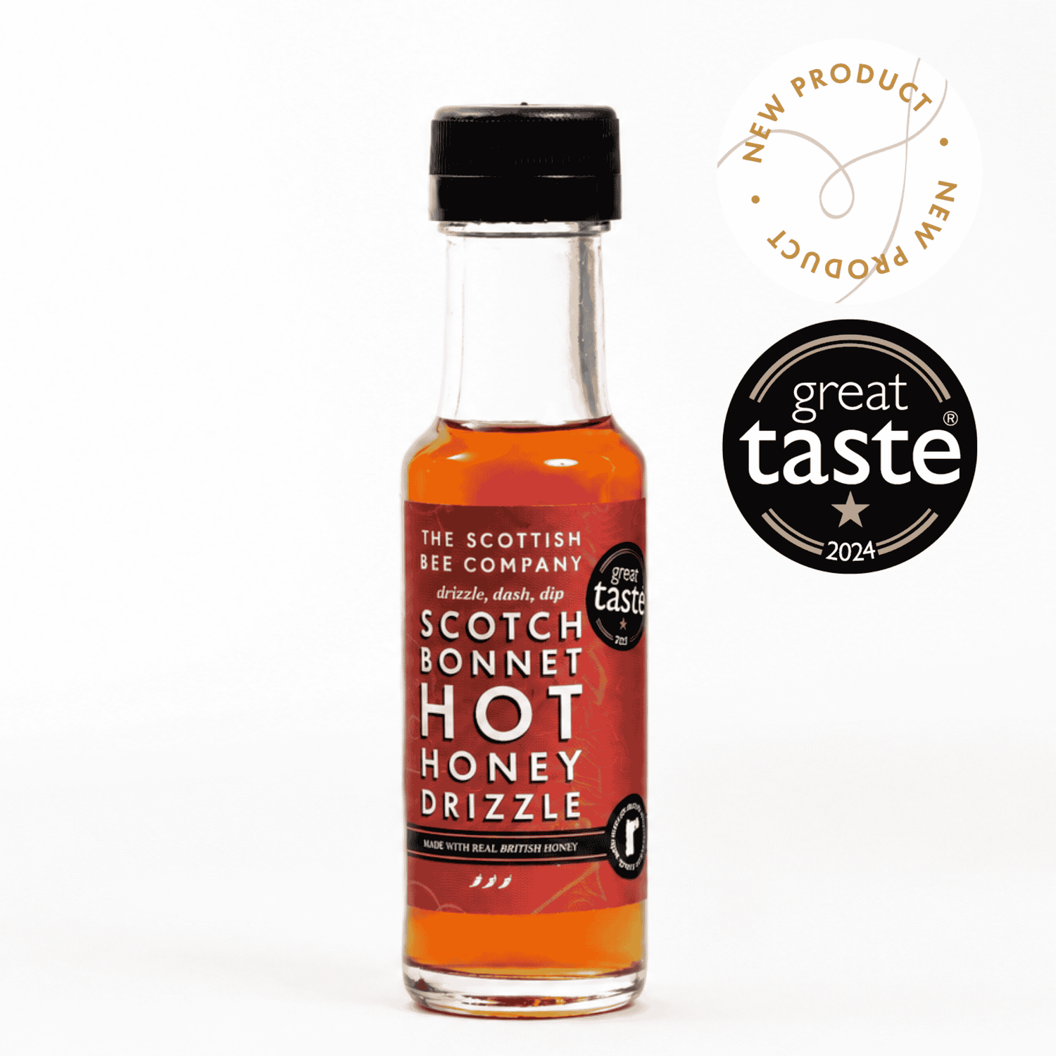 A small bottle of The Scottish Bee Company Scotch Bonnet Hot Honey Drizzle syrup with amber liquid and a red label, shown on a white background with a &